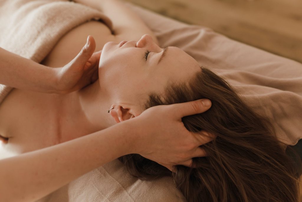 a person massaging a woman s face