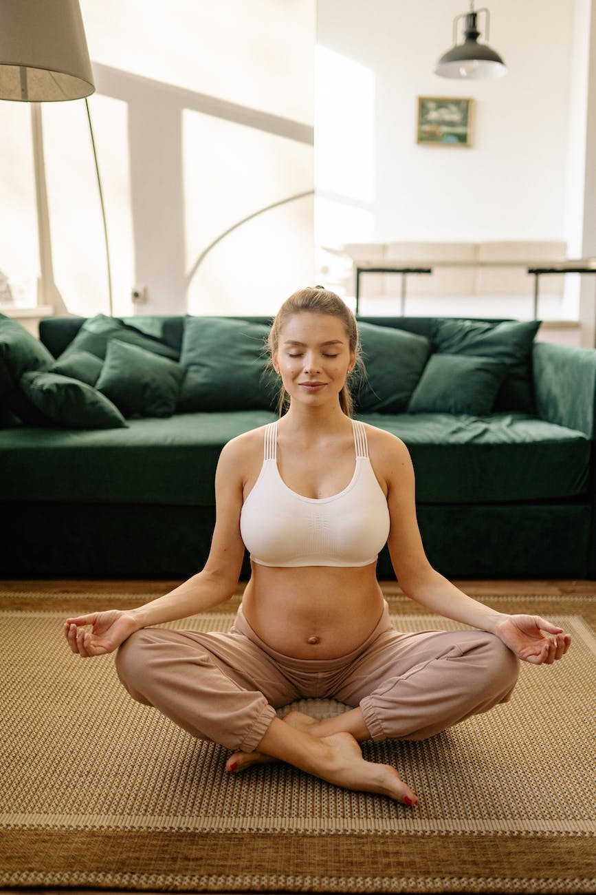 a pregnant woman meditating at home